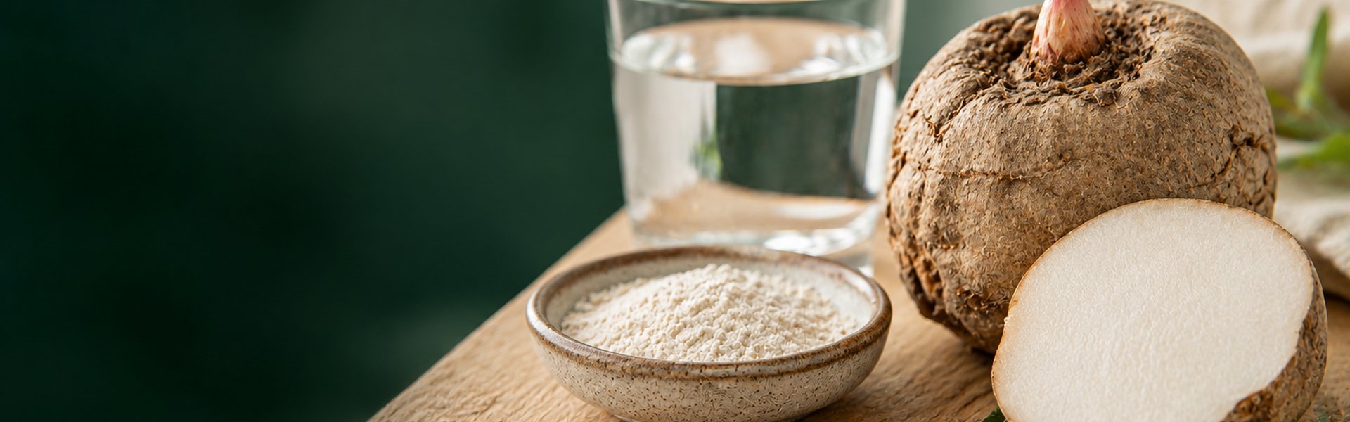 Tubercule de konjac bio tranché et gélules de glucomannane posés sur un plan de travail en bois clair